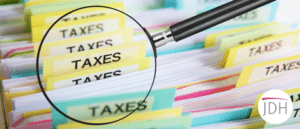 A magnifying glass looking at tax files to depict tax investigations