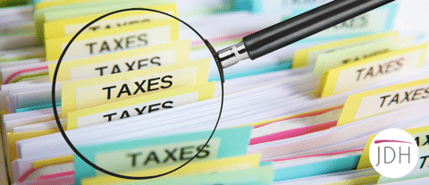 A magnifying glass looking at tax files to depict tax investigations